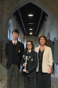 students with principal and trophy